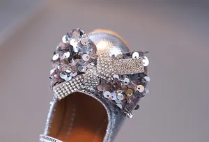Détail de chaussure princesse pour fille avec un grand nœud brillant orné de strass