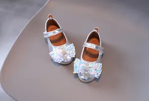 Dettaglio di scarpe Mary Jane argento per bambina con grande fiocco e chiusura a strappo