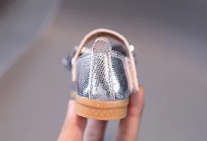 Détail de la texture pailletée argentée et de l'intérieur rose de la chaussure Mary Jane