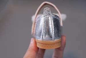 Dettaglio macro di scarpe con paillettes per bambine con cucitura sul tallone e suola morbida