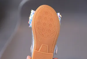 Dettaglio suola in gomma antiscivolo con numero 22 e fiocco glitter argento su scarpa bimba