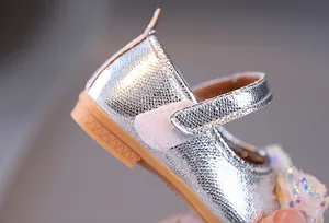 Dettaglio scarpe Mary Jane argento glitterate con fiocco in rete e suola antiscivolo