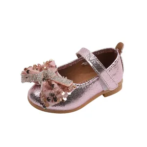 Détails des paillettes roses et du nœud strass brillant sur la chaussure de princesse fille