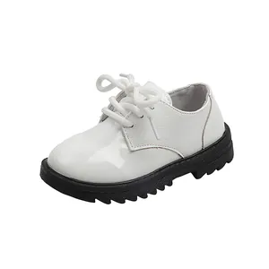 Detail of white embossed leather children shoes with black non-slip thick rubber soles