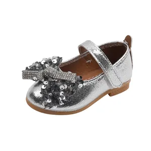 Détail de chaussure Mary Jane argentée pour fille avec nœud à paillettes et strass