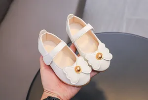 Détail de chaussures Mary Jane blanches pour filles avec nœud et texture cuir souple