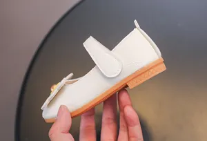 Détail de chaussure Mary Jane crème avec texture litchi et fleur de perle
