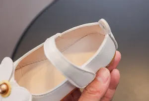 Gros plan de chaussures Mary Jane blanches montrant la texture et la doublure beige