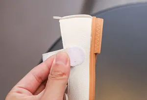 Détail de chaussure Mary Jane blanche pour fille montrant le cuir et le velcro