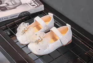 Détail de chaussure Mary Jane blanche avec nœud en résille, perle et paillettes