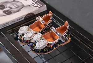 Details der Pailletten Mary Janes mit hohler Schleife und Strass auf einem Modemagazin