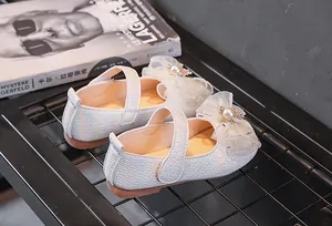 Détail de chaussures Mary Jane blanches pour filles avec nœud en dentelle et perle