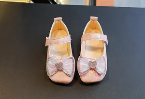 Detailed top view of pink girls princess shoes with woven texture and rhinestone bow