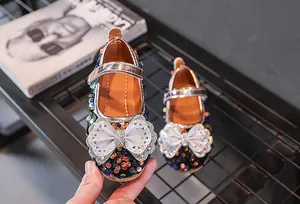 Detail von funkelnden Pailletten-Prinzessinenschuhen mit großer Schleife und Strass-Dekor