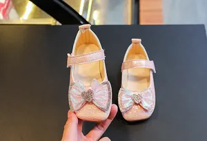 Detailed macro view of pink girls' princess shoes with glittery bow and heart gemstone
