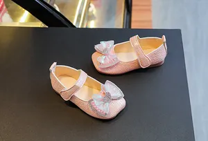Detail of pink Mary Jane shoes for girls with woven texture and iridescent bow ornament