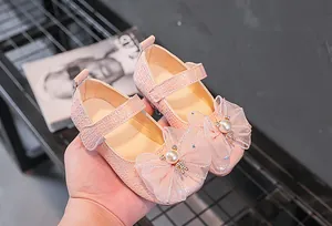 Détail de chaussures Mary Jane roses pour filles avec texture tissée et nœud perlé
