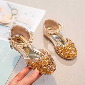 Détail de chaussures Mary Jane dorées pour filles avec perles et pendentif en cœur