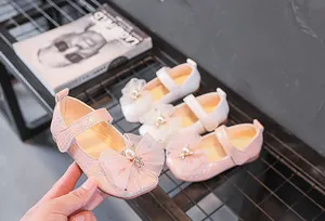 Détail de chaussures Mary Jane pour filles avec texture tissée, nœud en résille et perle