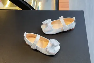 Detail of girls princess shoes with iridescent woven texture and rhinestone heart bow