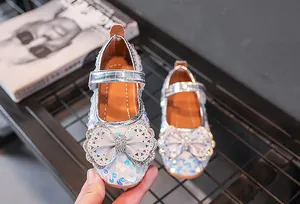 Nahaufnahme silberner Mädchen-Prinzessin-Schuhe mit Schleife und Strass-Details