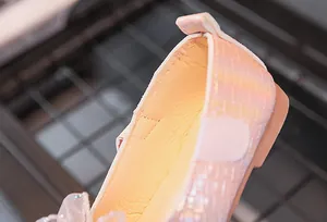 Détail de chaussures de princesse roses avec texture tissée nacrée et fleurs en paillettes