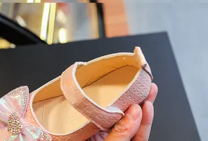 Close-up of pink girls princess shoe with sparkling rhinestone heart bow and velcro strap