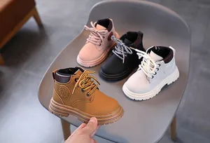 Close-up of children's fashion boots in pink, yellow, black and white colors