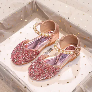 Détail de chaussures de princesse rose doré pour filles avec paillettes et perles