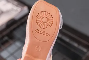 Gros plan de la semelle de chaussure rose pour fille avec motif floral et marquage taille 25
