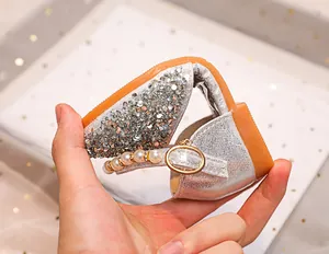 Détail de la semelle souple et de la bride perlée sur chaussures pailletées argent