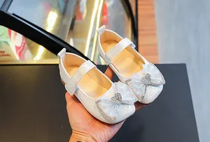 Detail of white girls' Mary Jane shoes with woven texture and rhinestone heart bow