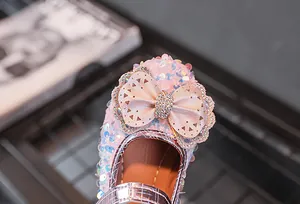 Detailaufnahme rosa Mädchenschuhe mit großer Schleife und funkelndem Strass-Besatz