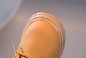 Close-up of pink children boots with durable leather material and woven laces
