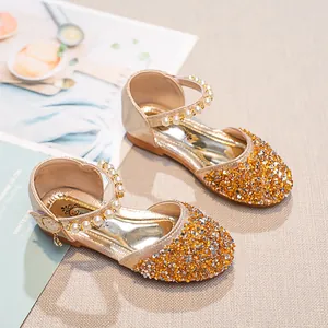 Vue détaillée de chaussures de princesse à paillettes dorées avec boucle en perles et cristal