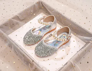 Détail de sandales argentées à paillettes pour filles avec bride perle et semelle laser