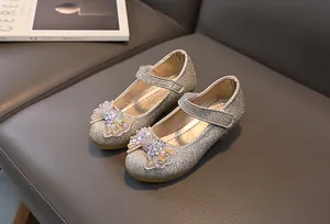 Close-up of glitter girls princess shoes with sparkling crystal bow and gold sequin finish