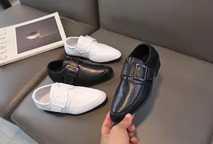 Dettaglio di scarpe eleganti per bambini con fibbia in finta pelle nera e bianca