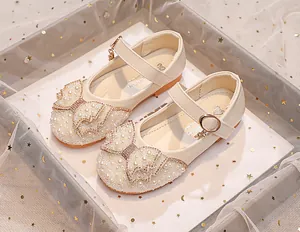 Detailed view of girls' white Mary Jane shoe with pearl bow and sparkling rhinestone accents