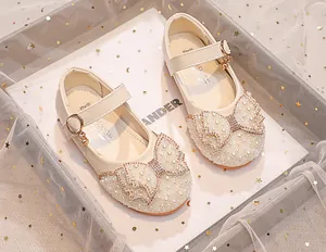 Detailed view of girls princess shoes with large pearl bow and sparkling rhinestone accents