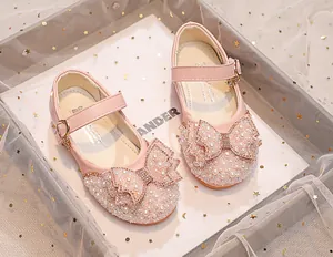Detail of pink girls princess shoes with sparkling rhinestones, pearls and bow decoration