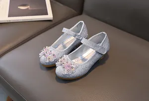 Close-up of sparkling silver glitter Mary Jane shoes with floral beaded bow detail