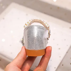 Gros plan de chaussures Mary Jane argentées à paillettes avec perles et semelle gomme