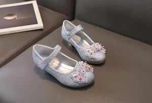 Detail of silver sequin Mary Jane shoes with floral bow and low block heels for girls