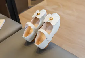 Detail of girls' cream Mary Jane shoes with double bows and non-slip rubber soles
