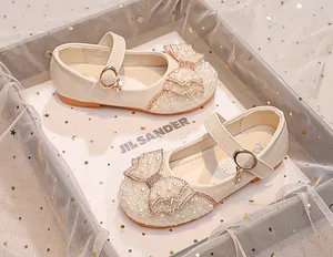Close-up of girls' Mary Jane shoes with pearls, rhinestones and layered bow details