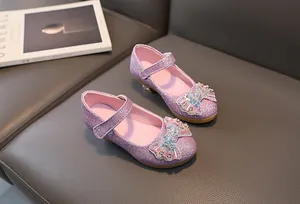 Detailed view of purple glitter girls' princess shoes with bow on a leather sofa