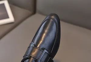 Dettaglio scarpe eleganti da bambino in pelle nera con cuciture rifinite e fibbia monk