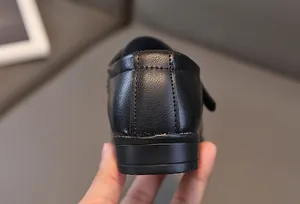 Dettaglio del tallone in pelle nera per bambino con robuste cuciture doppie a vista