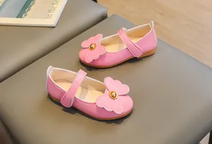 Detail of pink girls Mary Jane shoes with large bow and golden bead decoration
